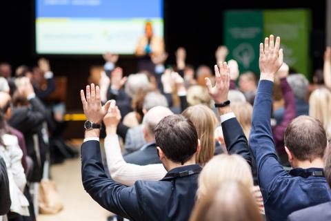 Participants of an event raising hands Participants of an event raising hands during a plenary