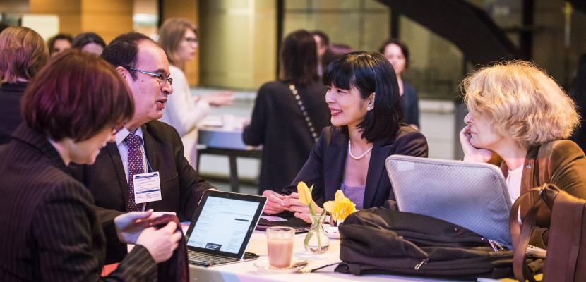 People speaking around a table at an event People speaking around a table at an event