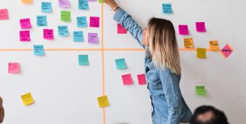 Woman sticking sticky note on wall Woman sticking sticky note on wall
