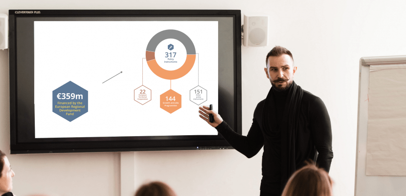 a man presenting facts and figures a man presenting facts and figures of the programme Interreg Europe on a screen in front of a audience